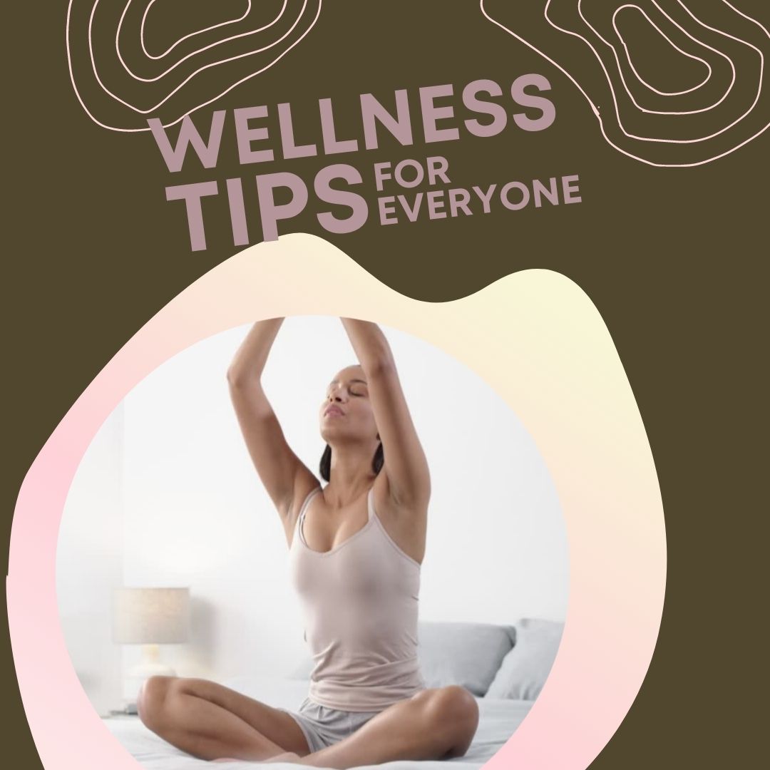 woman sitting cross-legged on a bed with her eyes closed and raising her hands above her head