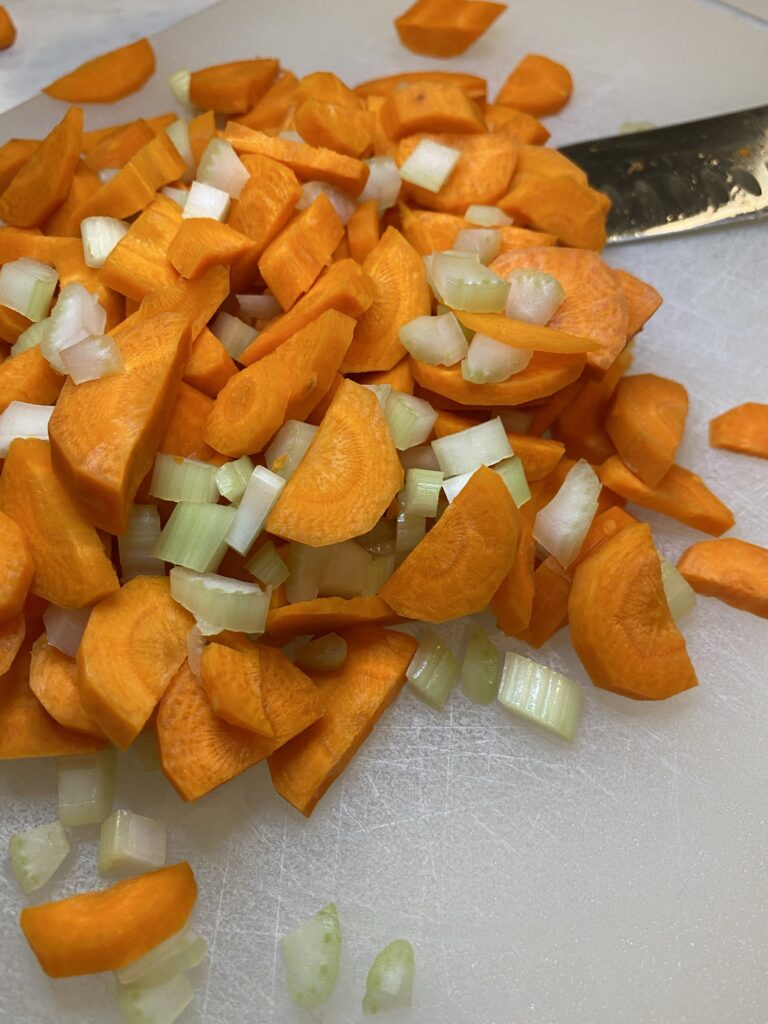 diced carrots and celery on a white cutting board