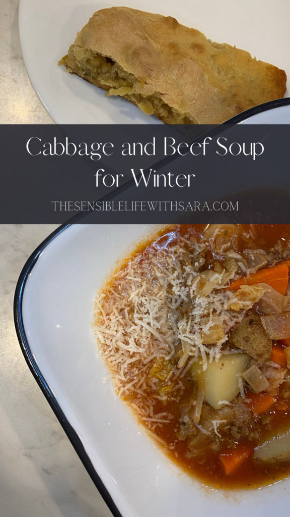 cabbage and beef soup topped with cheese next to a plate of bread