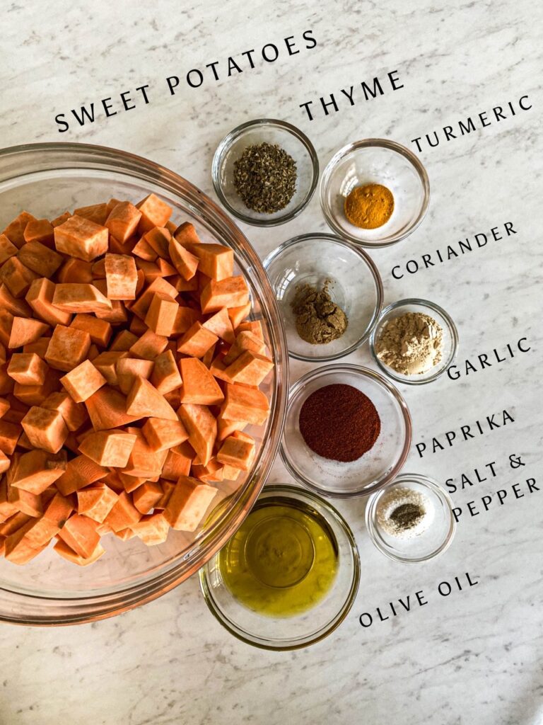 glass bowls on a white counter filled with diced sweet potatoes and seasonings.