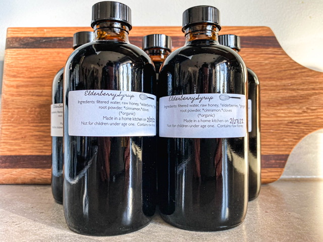 amber bottles labeled elderberry syrup sitting on a grey counter