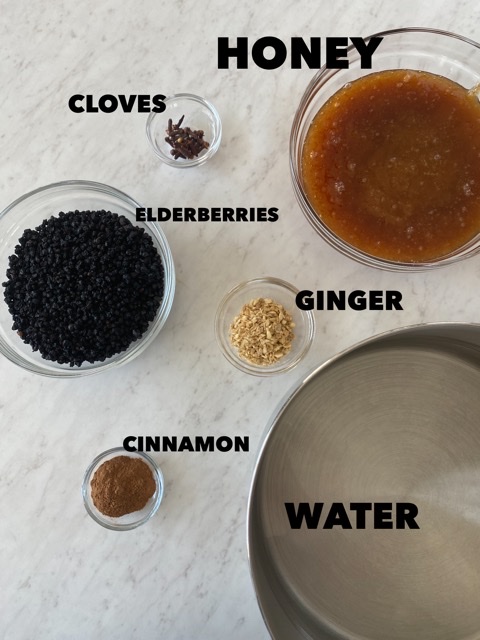 elderberry syrup ingredients in separate bowls on a white counter 