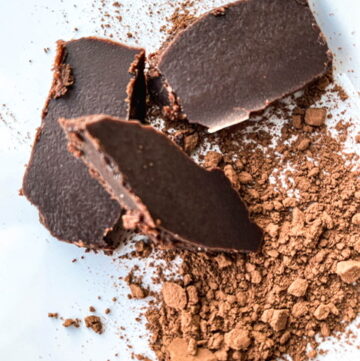 chocolate chunks on a white tray dusted with cocoa powder