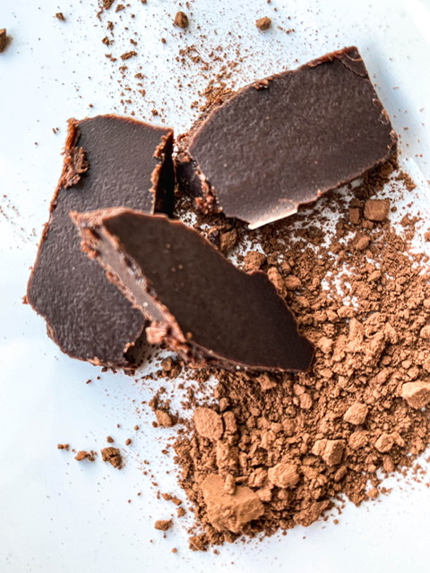 chocolate chunks on a white tray dusted with cocoa powder