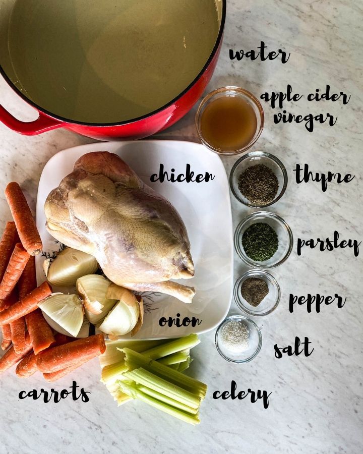 ingredients for nourishing bone broth on a white counter