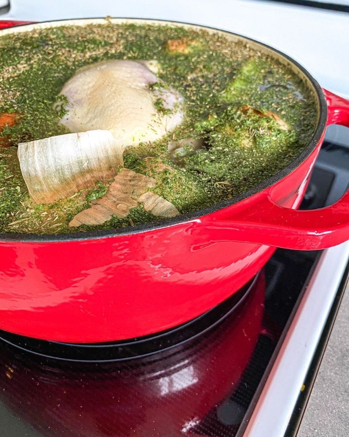 chicken and spices in a dutch oven on the stove