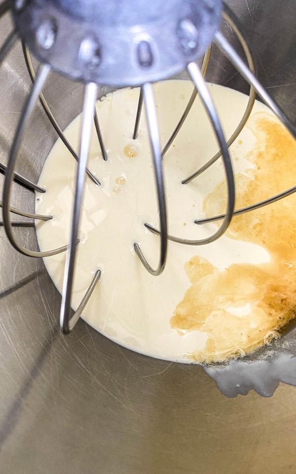 bowl with cream, maple, syrup, and vanilla and a whisk