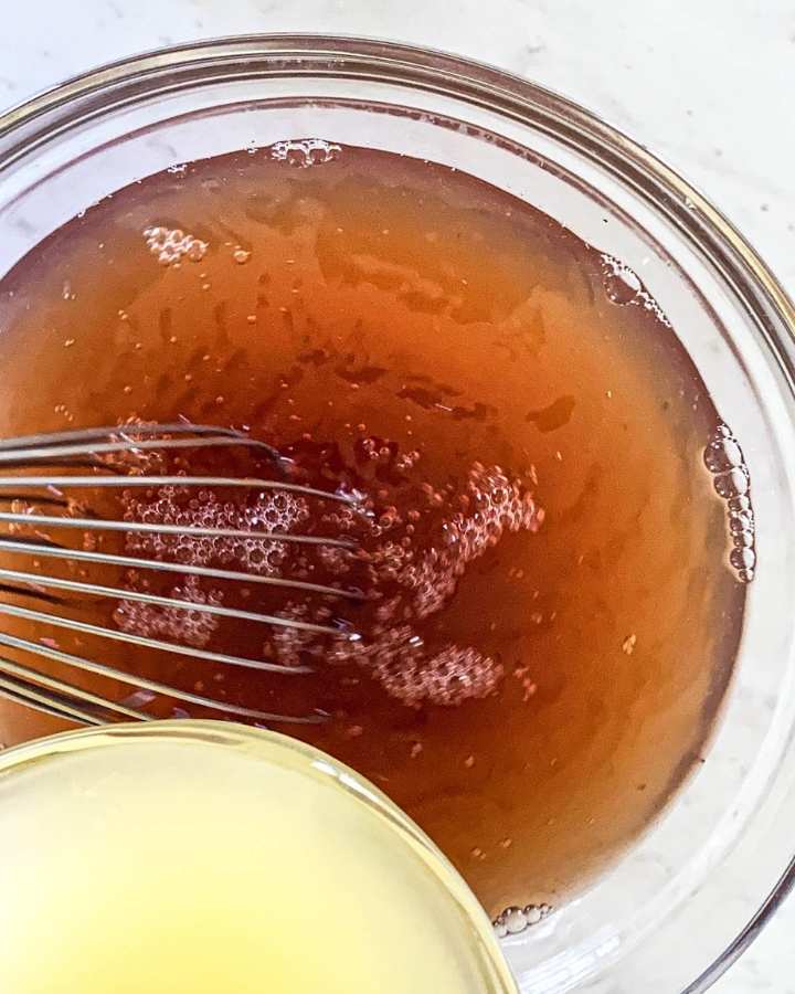 bowl of lemon juice next to a bowl of tea with a whisk 