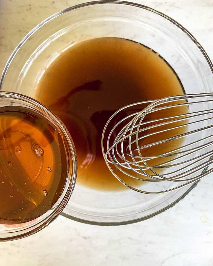 bowl of honey next to a bowl of tea with a whisk