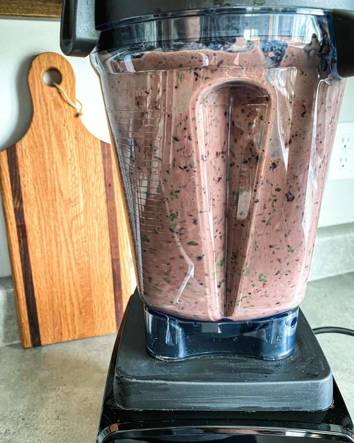 blender mixing a berry and beet greens smoothie