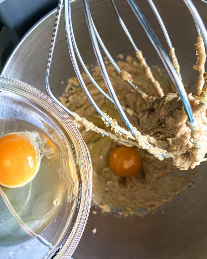 sourdough blueberry muffin batter with two raw eggs being poured into the bowl