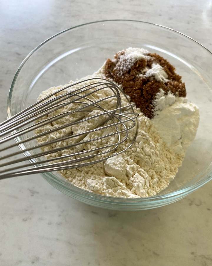 dry ingredients in a glass bowl with a wire whisk inside