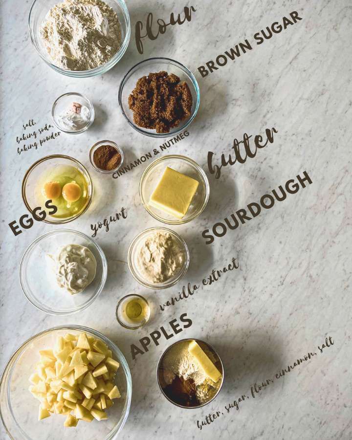 sourdough apple spice muffin ingredients in glass bowls own a white counter 