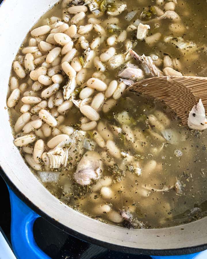 pot of chicken chili with a wooden spoon in it