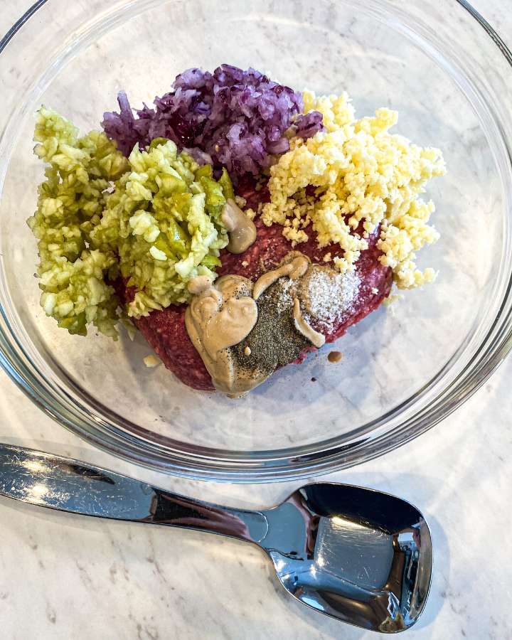 apple cheddar beef burger ingredients placed in a glass bowl