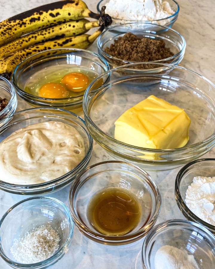 glass bowls filled with banana muffin ingredients on white counter