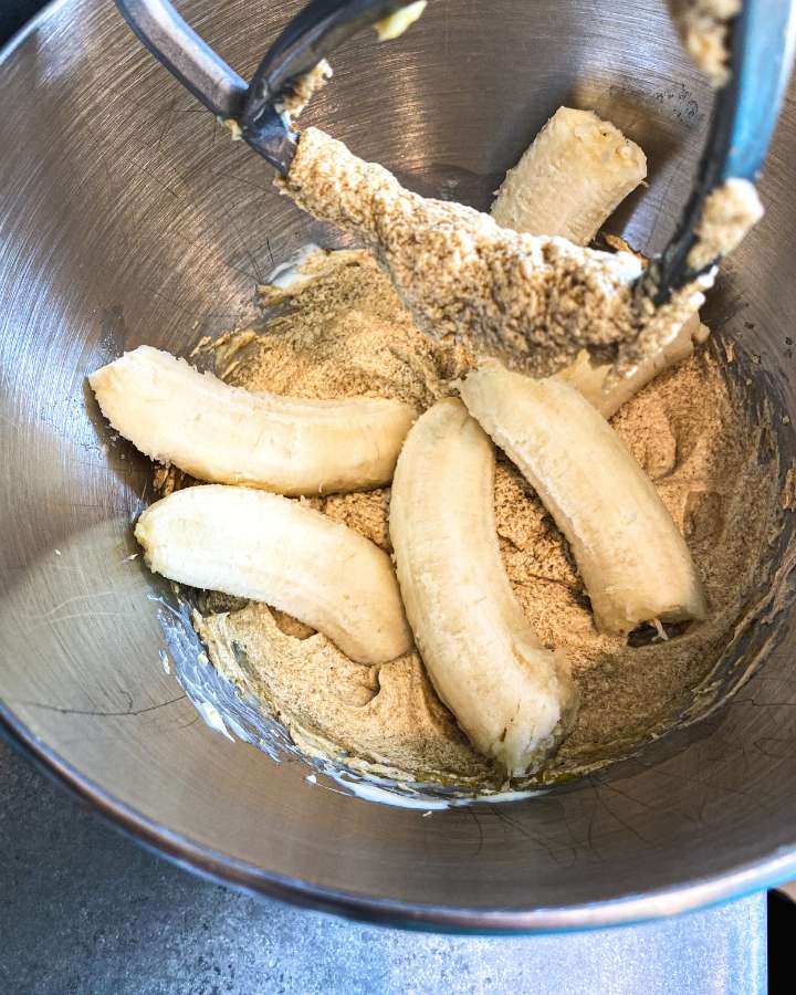 halves of bananas set in muffin batter in a mixing bowl