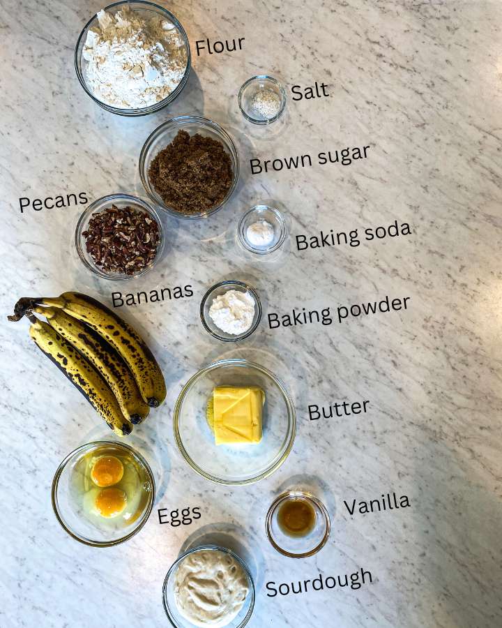 small bowls of ingredients to make banana muffins on a white counter