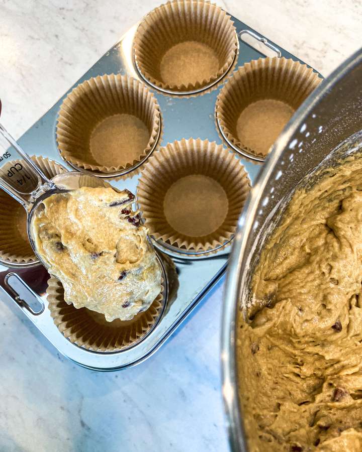 banana muffin batter being poured into muffin tins