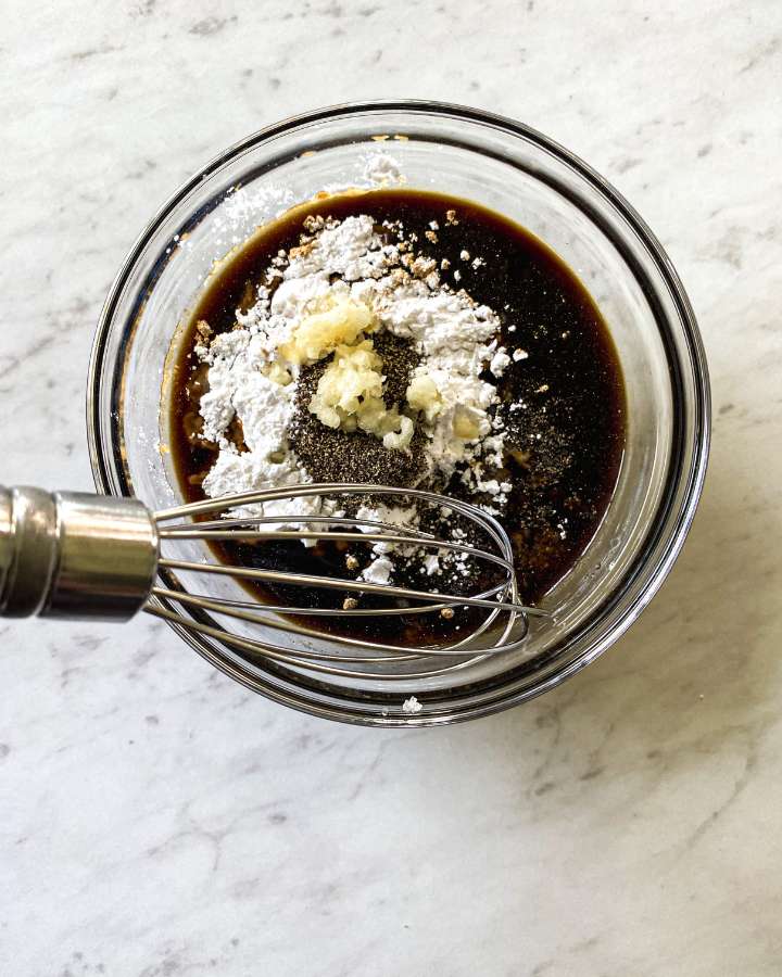 clear bowl filled with sauce ingredients on a white counter